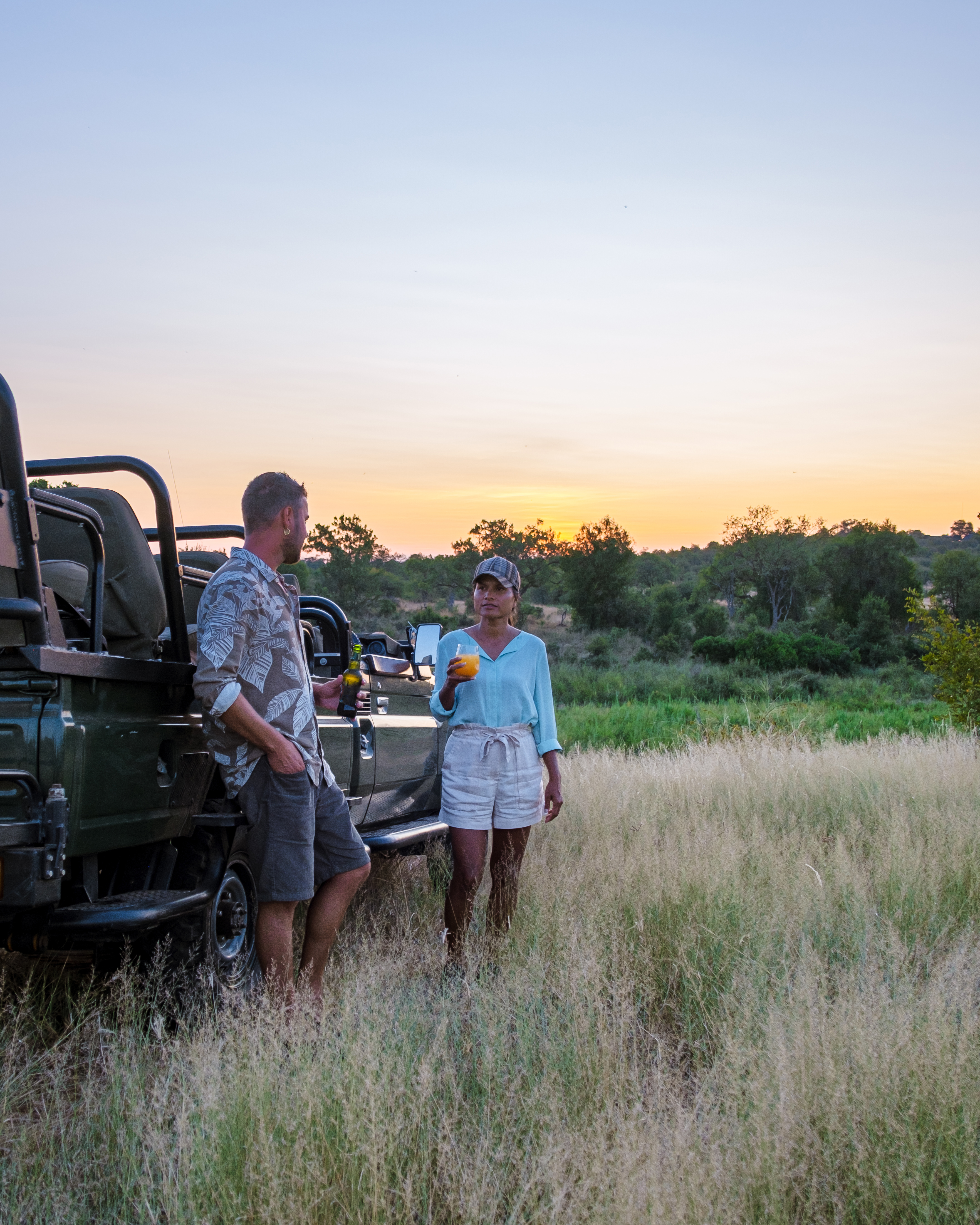 Honeymoon couple on a guided bush walk in Tanzania with an experienced guide tracking wildlife on foot in the early morning light