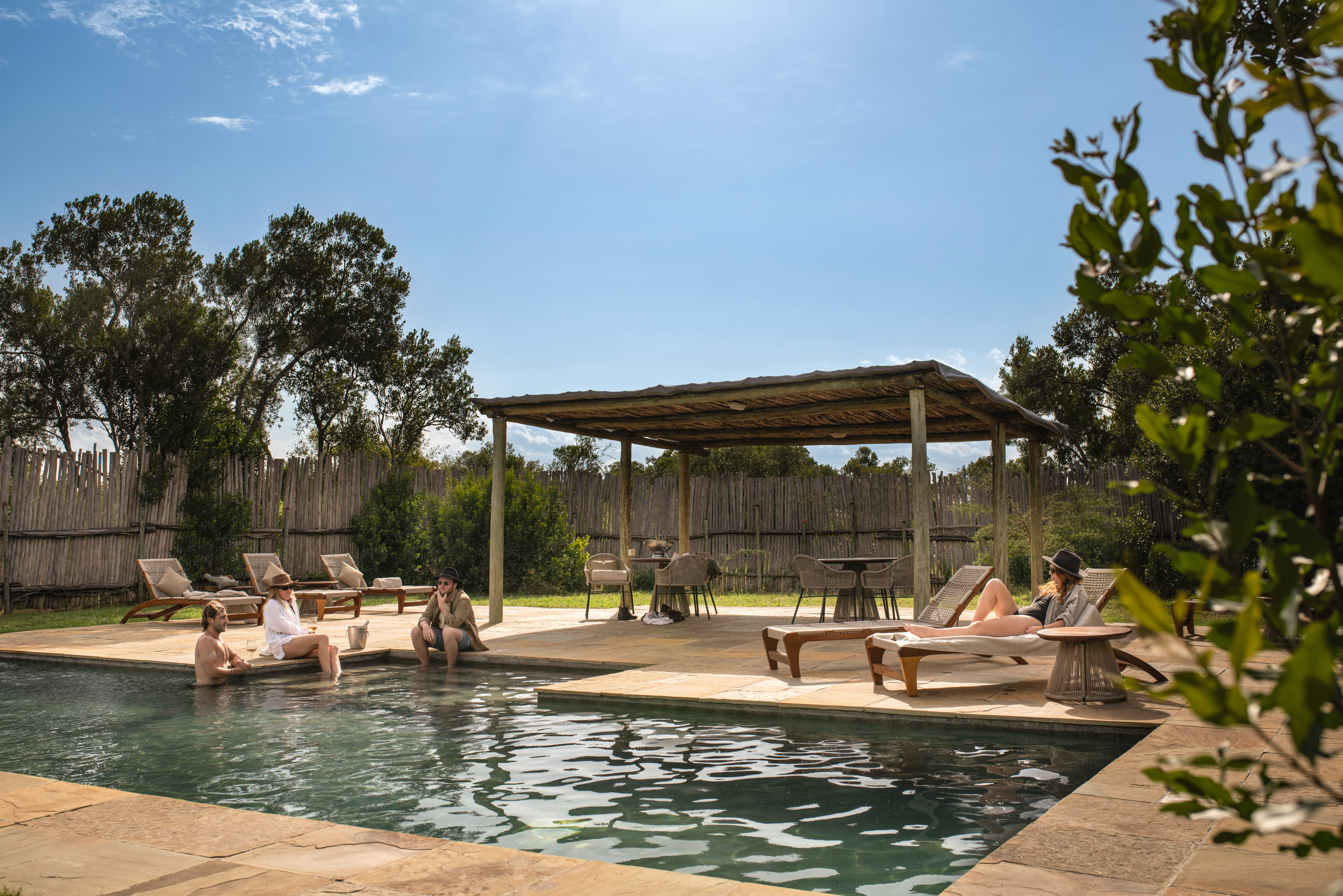 Children playing at an exclusive-use family safari camp with the African bush behind them