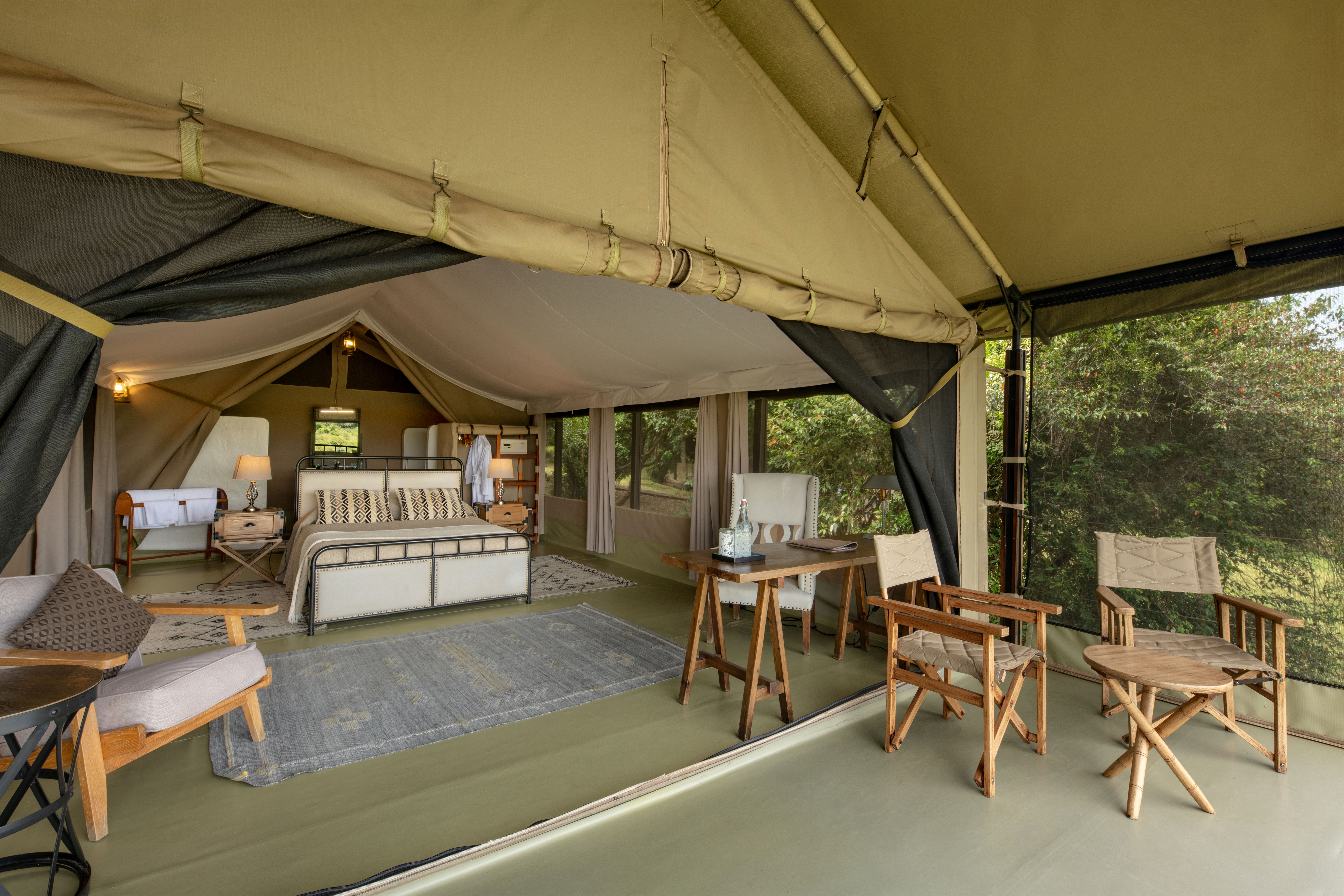 Elegantly furnished luxury tent interior at a Masai Mara conservancy camp in Kenya with views across the open plains