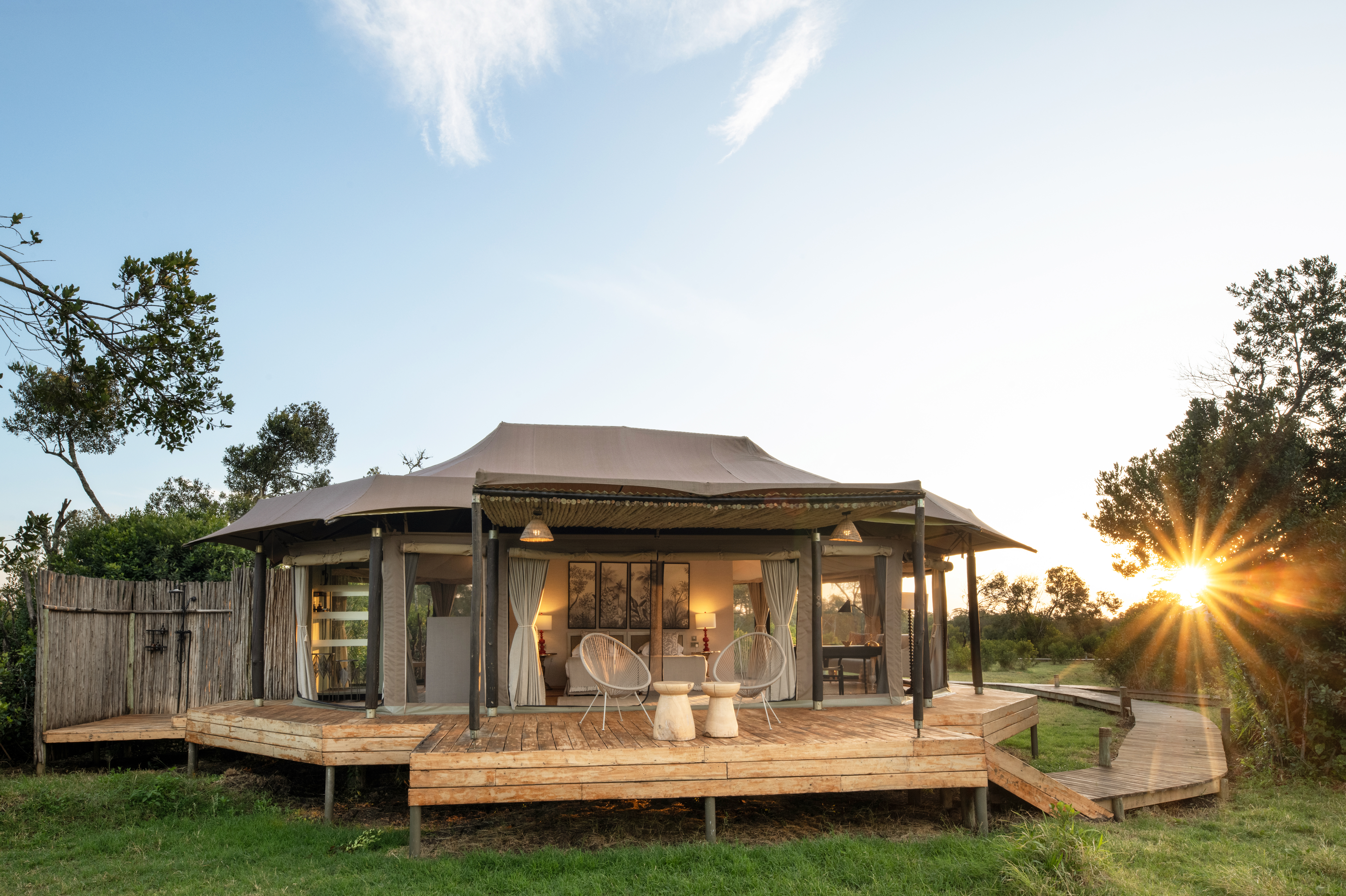 Interior of a luxury tent with open canvas walls overlooking the Serengeti at dawn