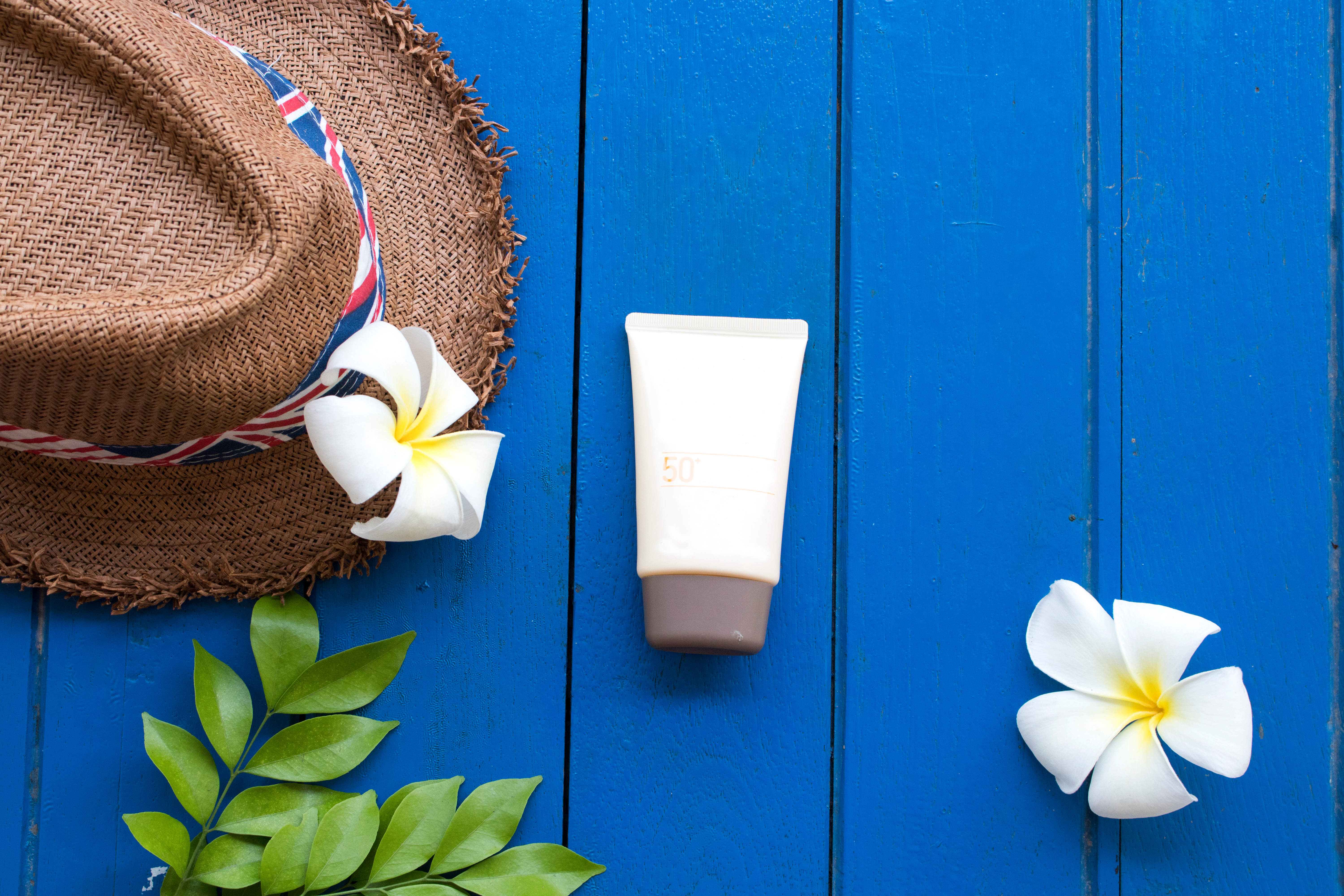 Safari traveller wearing a wide-brimmed hat and applying sunscreen before a morning game drive in Tanzania's Serengeti